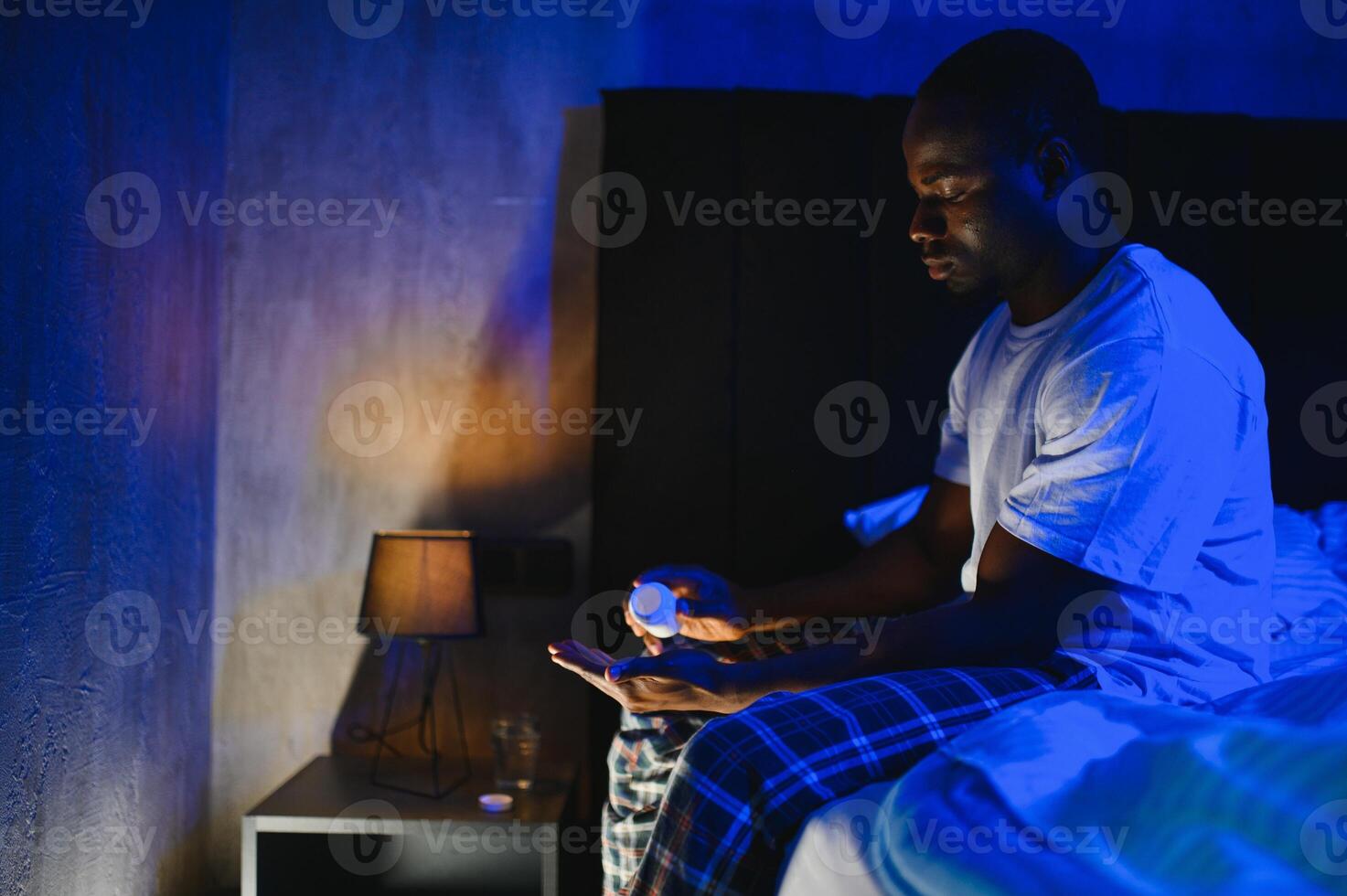 An African man has problems with insomnia. Takes sleeping pills for better sleep photo