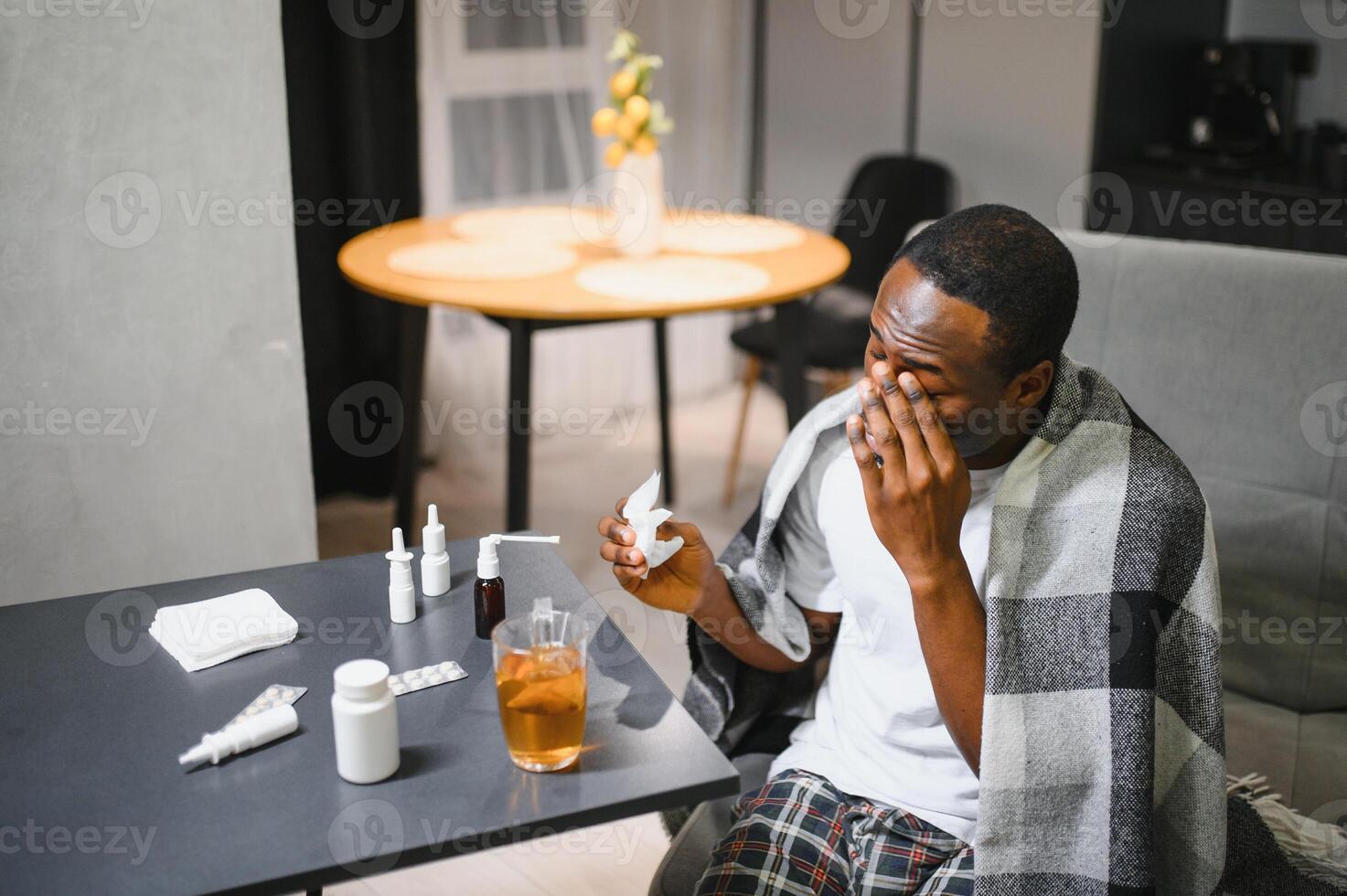 An African American man is being treated for a cold and flu at home photo