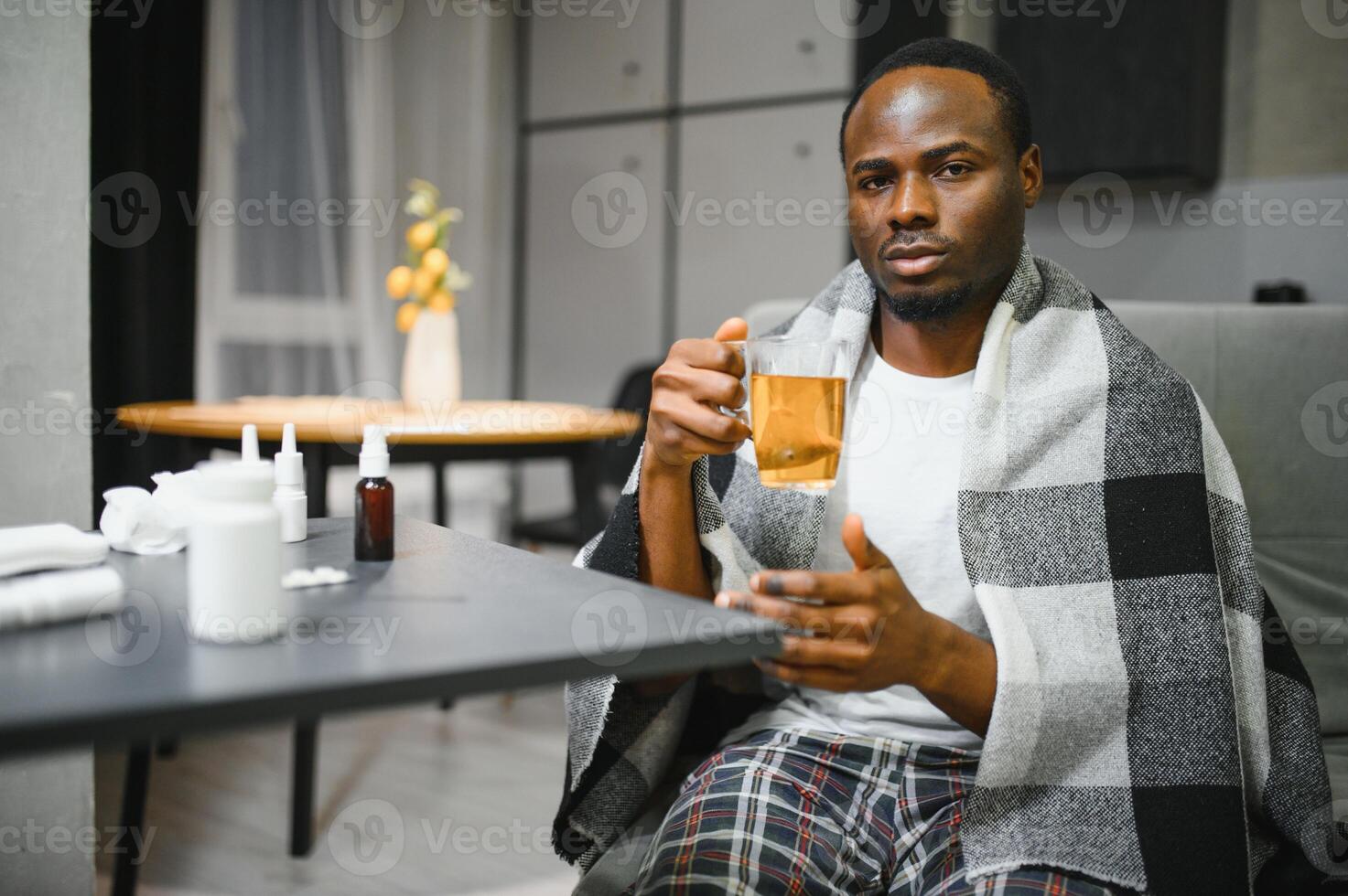 An African American man is being treated for a cold and flu at home photo