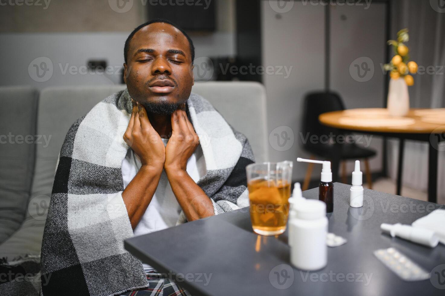 Sick African man with sore throat. Portrait of ill black man suffering from sore throat due to cold, flu, allergy, polluted air, dust, smog photo