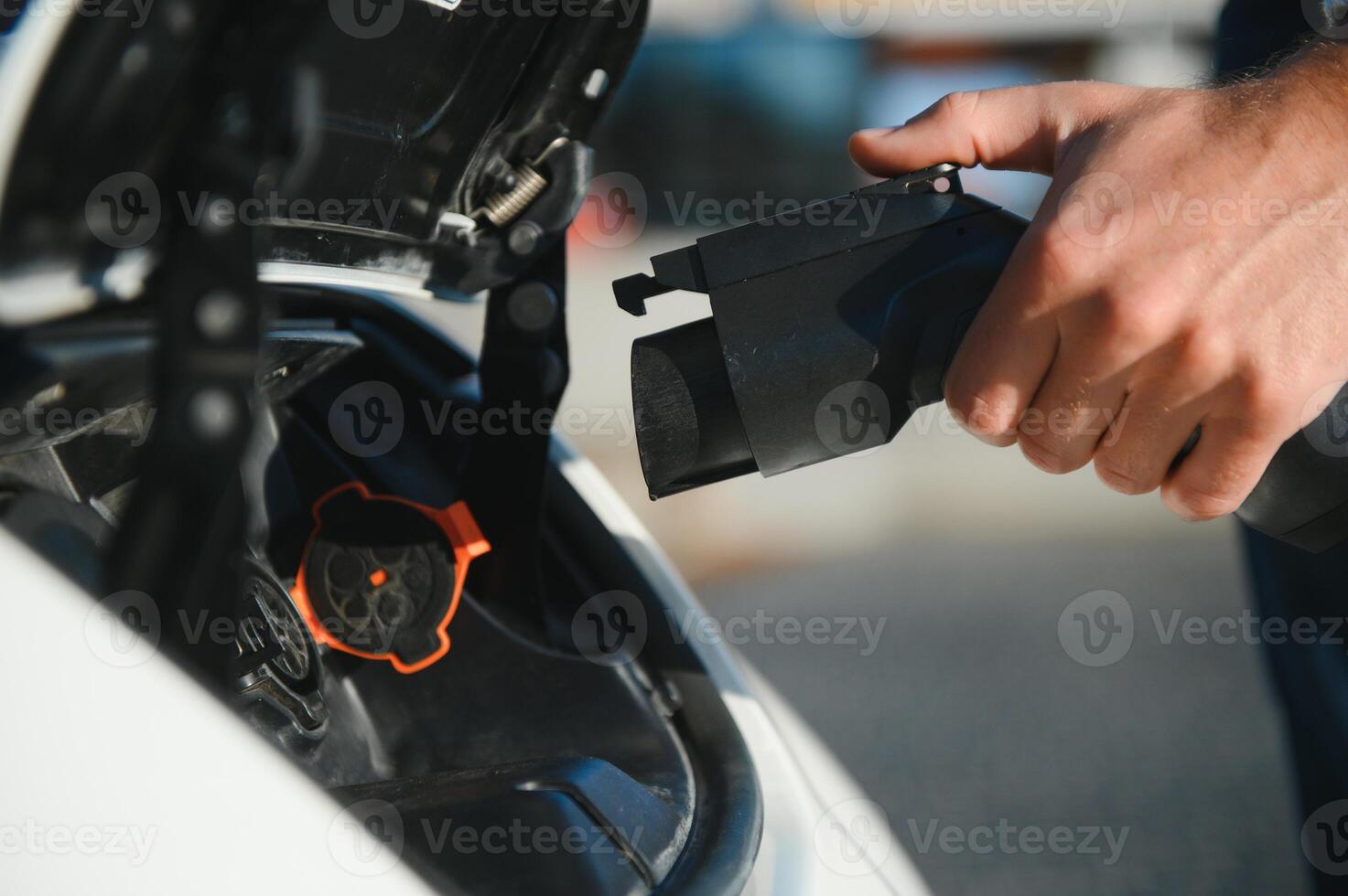 Smiling man unplugging the charger from the car photo
