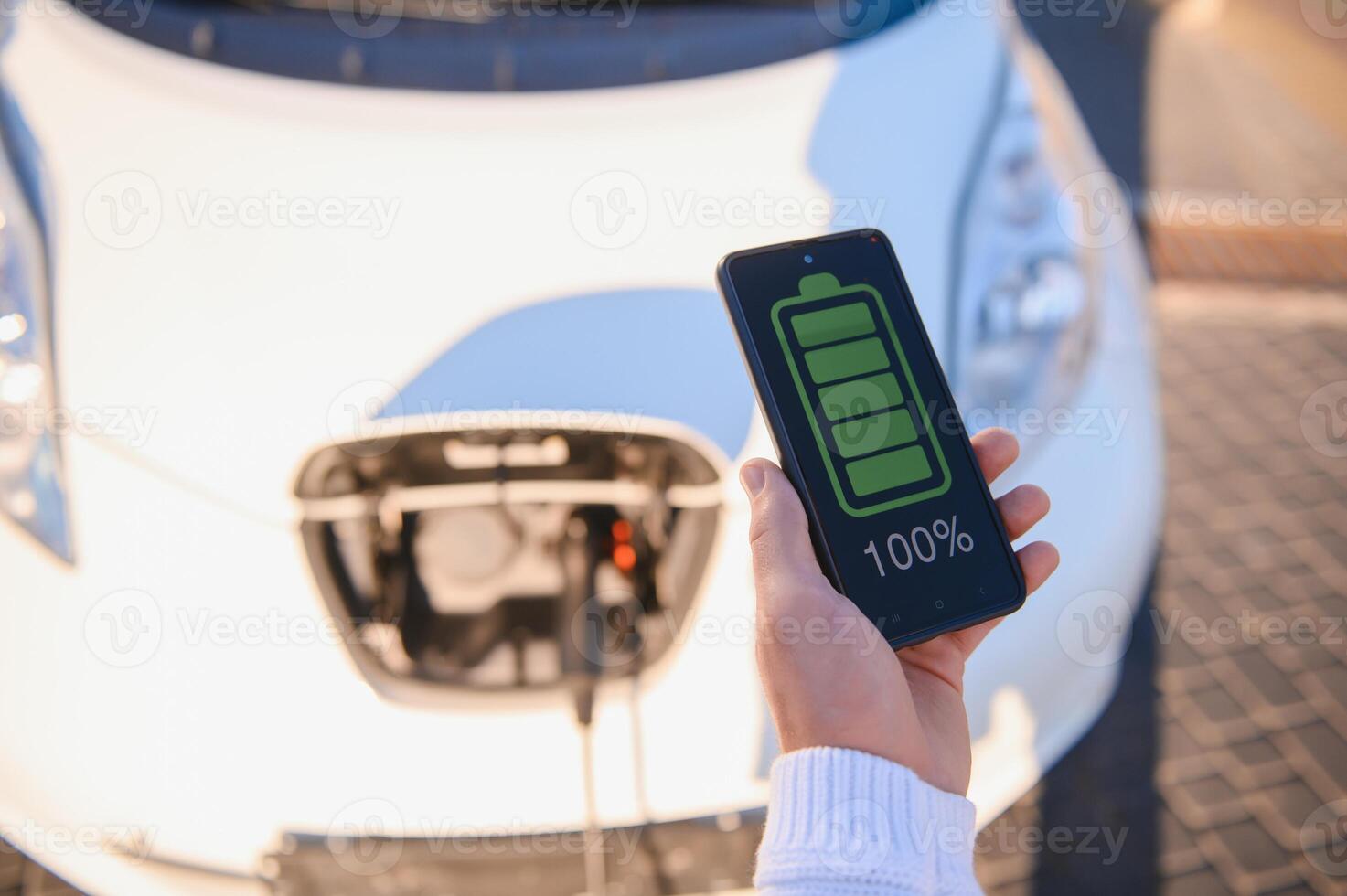 Man charges an electric car at the charging station photo