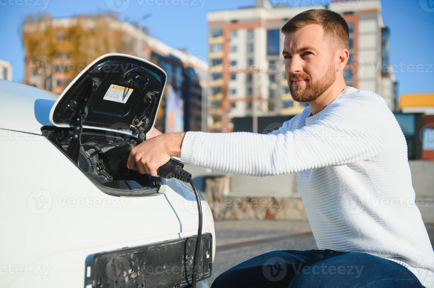 Young man charging his car photo