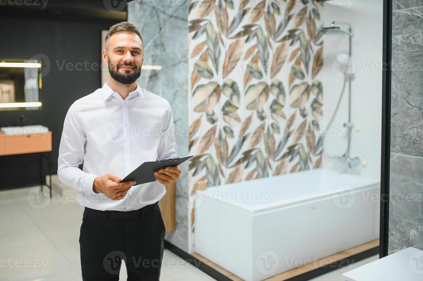 Happy salesman plumber man with paper tablet on plumbing shop photo