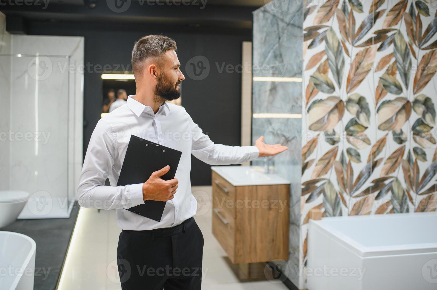 Happy salesman plumber man with paper tablet on plumbing shop photo