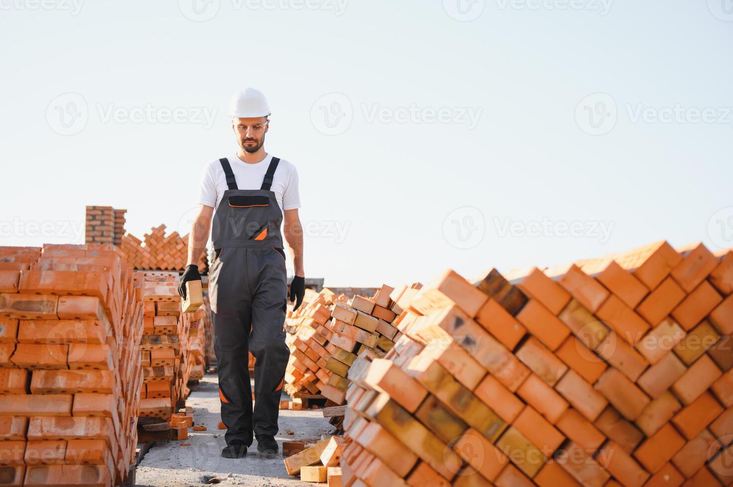Installing brick wall. Construction worker in uniform and safety equipment have job on building photo
