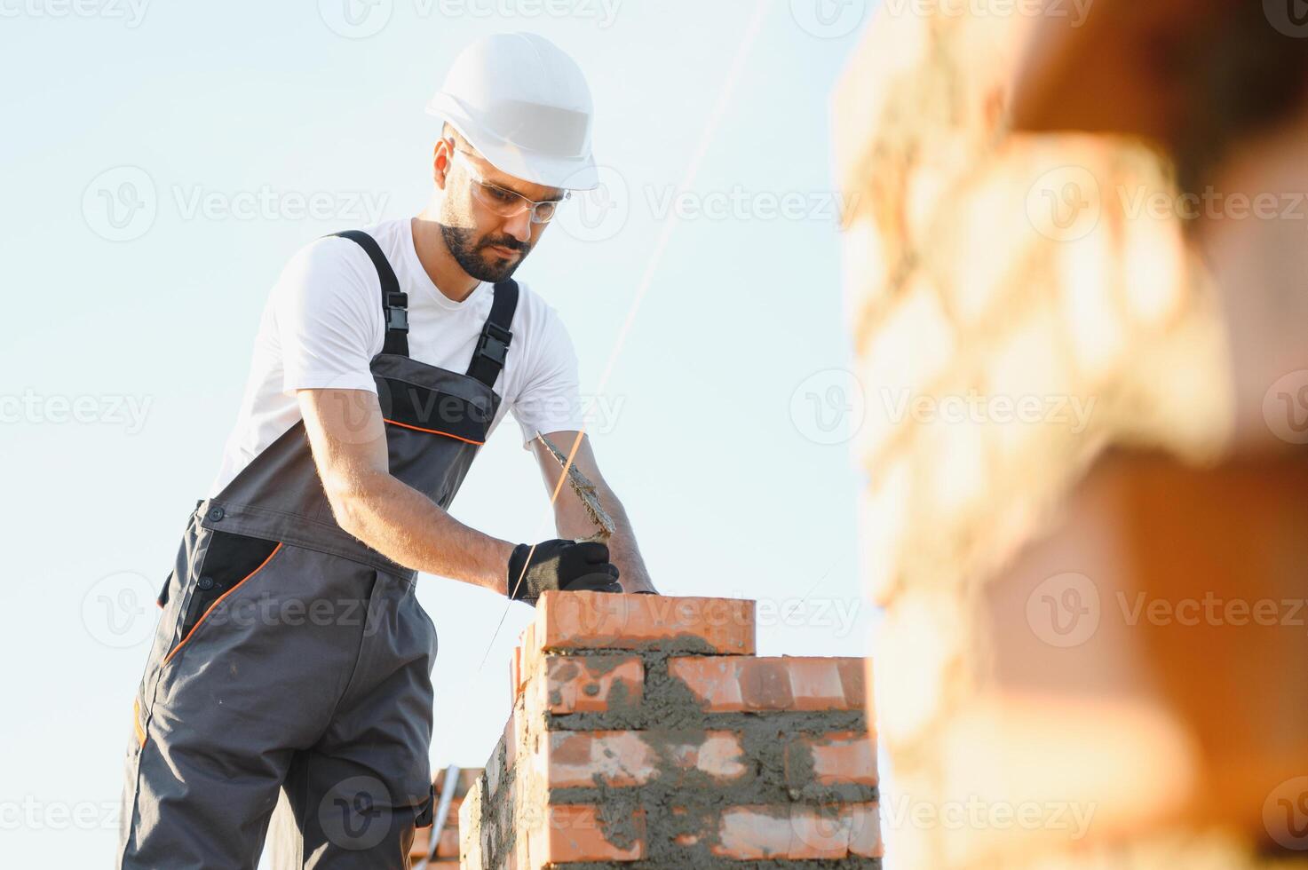 Construction worker in uniform and safety equipment have job on building. Industrial theme photo