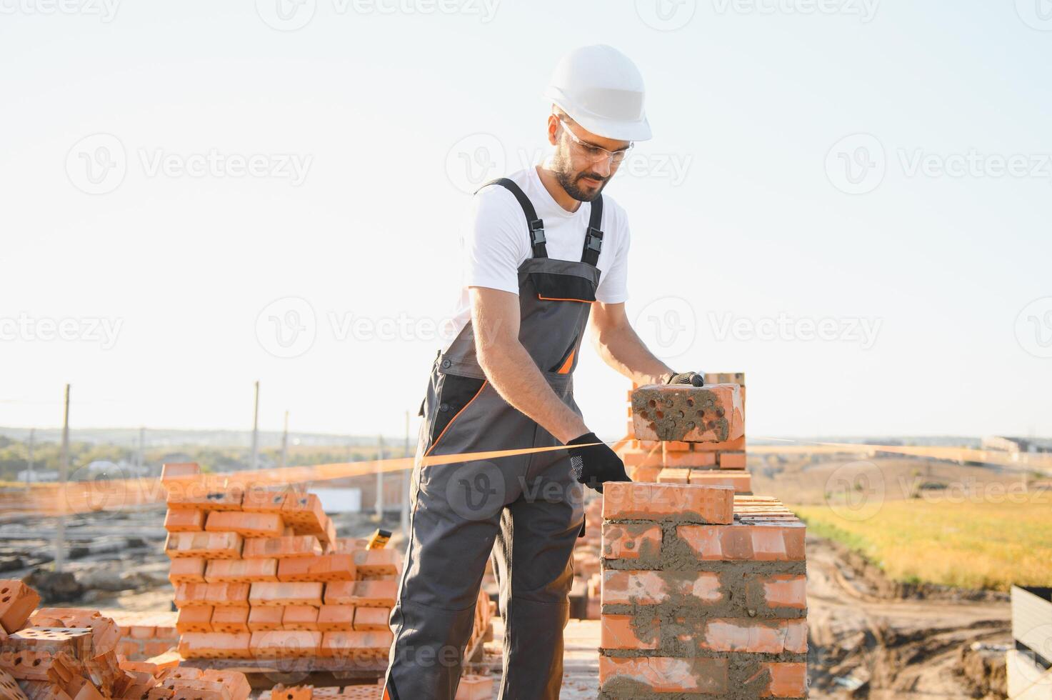 Construction worker in uniform and safety equipment have job on building photo