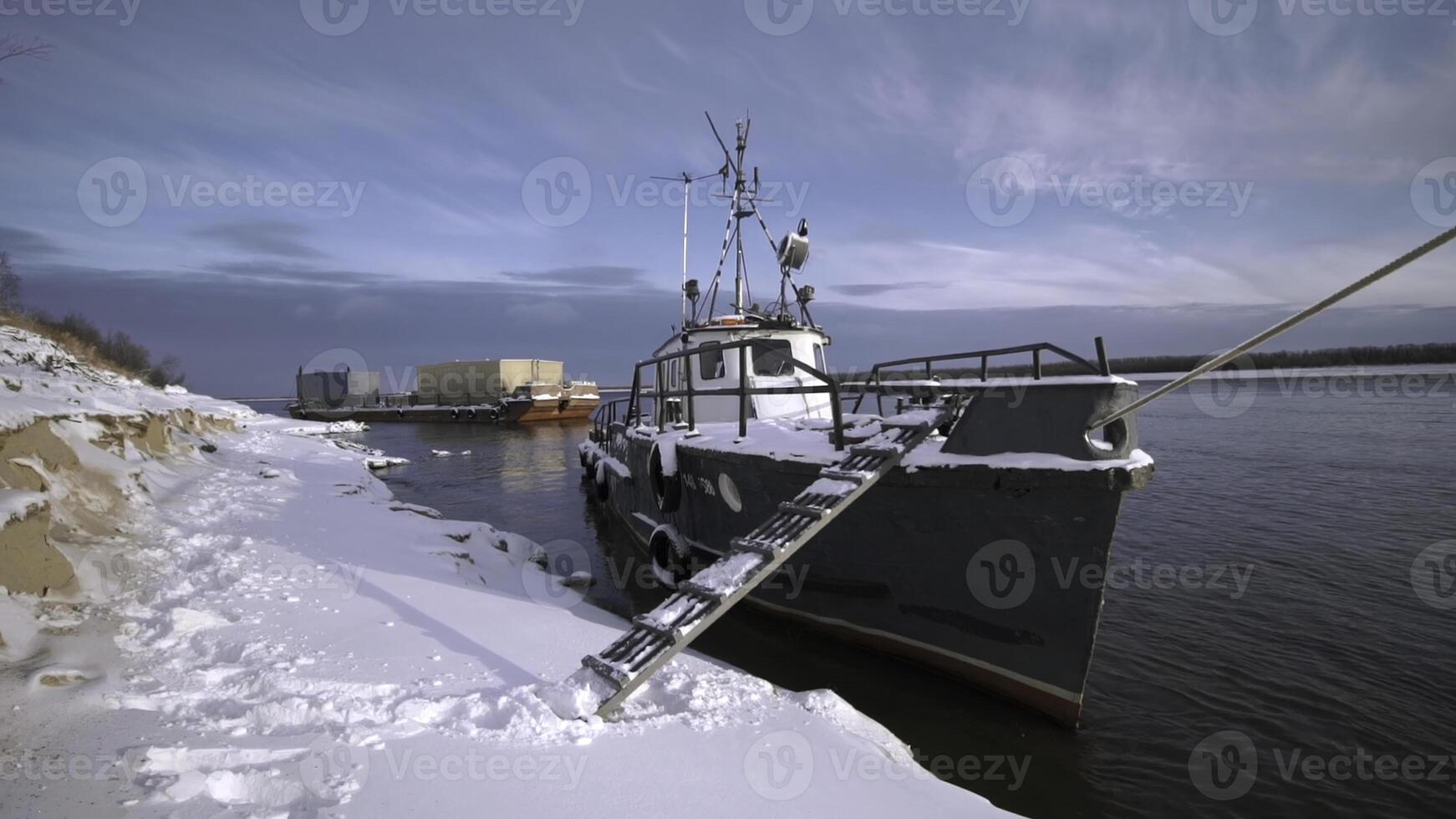 Ships standing right under the rays of the bright sun.Clip. Large ships in the river with large cargo devices stand against the background of the bright sun during the day. photo