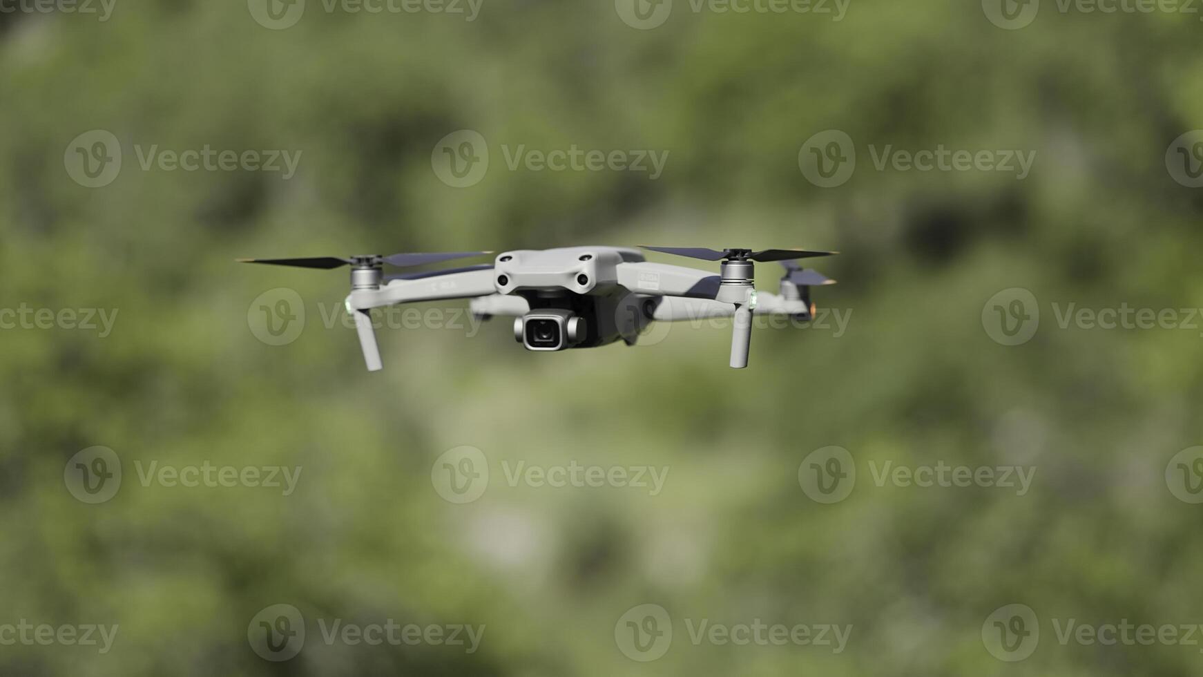 Flying drone in air. Action. Drone flies over green trees. New model of drone in air shoots green trees in summer photo