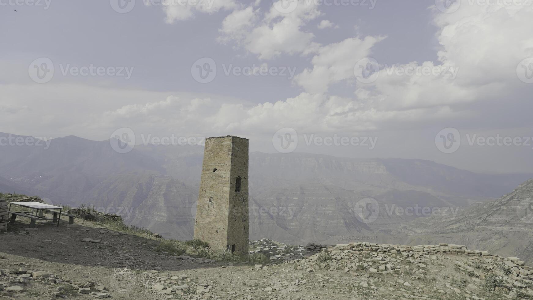 Mountain landscape with stone towers. Action. Stone fortress towers in mountains. Historical stone towers in mountains on background of sky photo