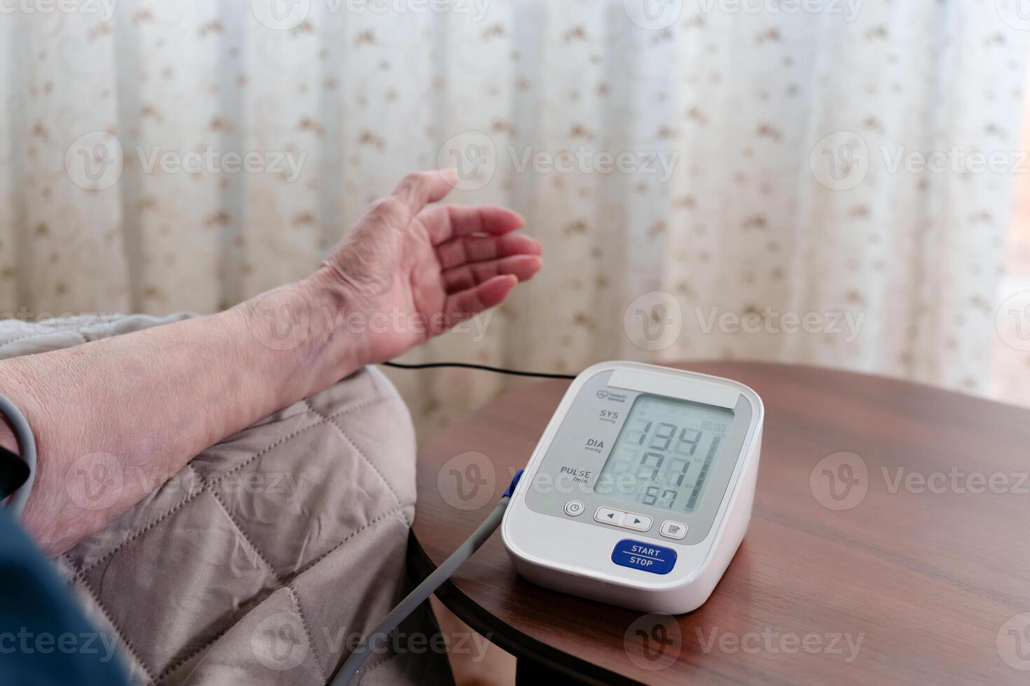 An impersonal woman measures vital signs with a tonometer, the numerical display at the center of the conceptual health care image photo