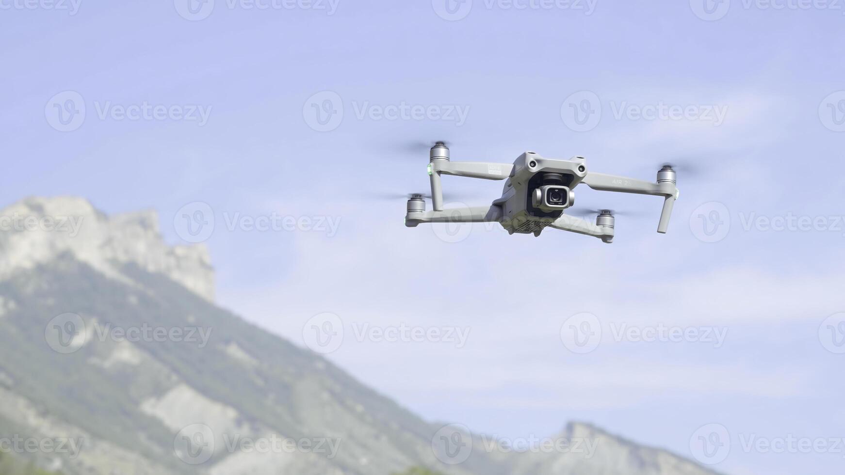 Aerial view of a quadcopter flying above green mountains on morning haze background. Action. Drone filming of natural landscape. photo