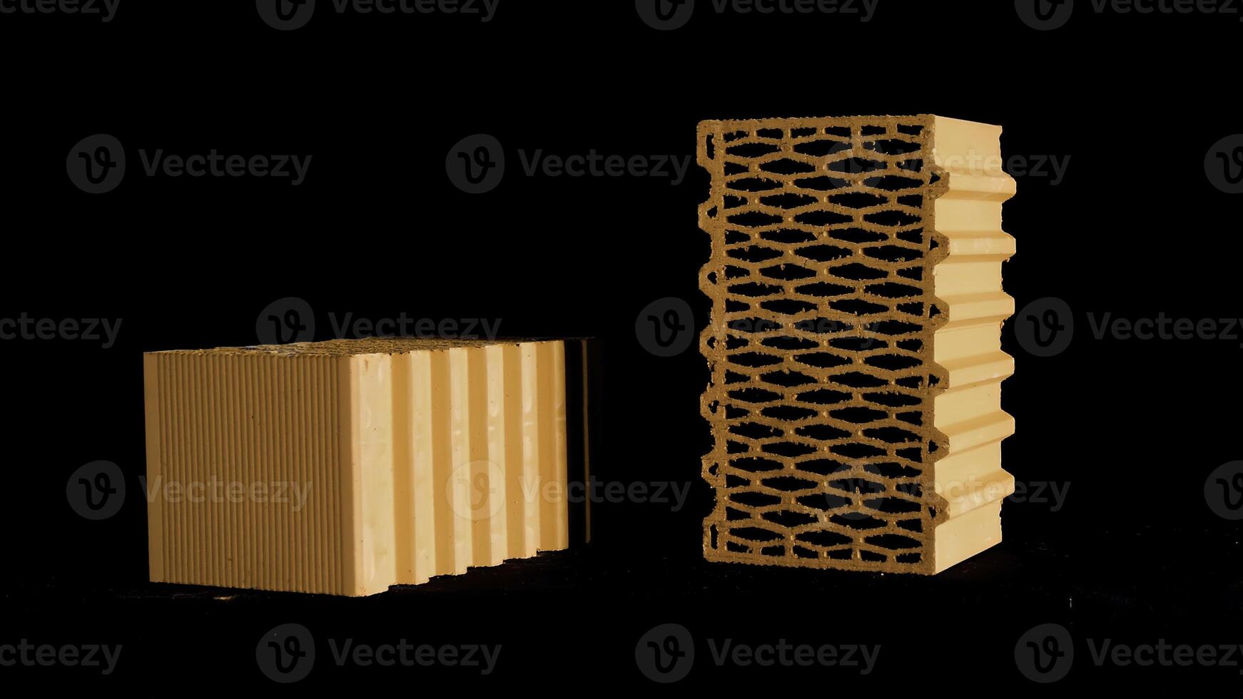 Two new perforated red bricks placed on black stand, building and construction materials concept. Stock footage. Bricks moving on black background. photo