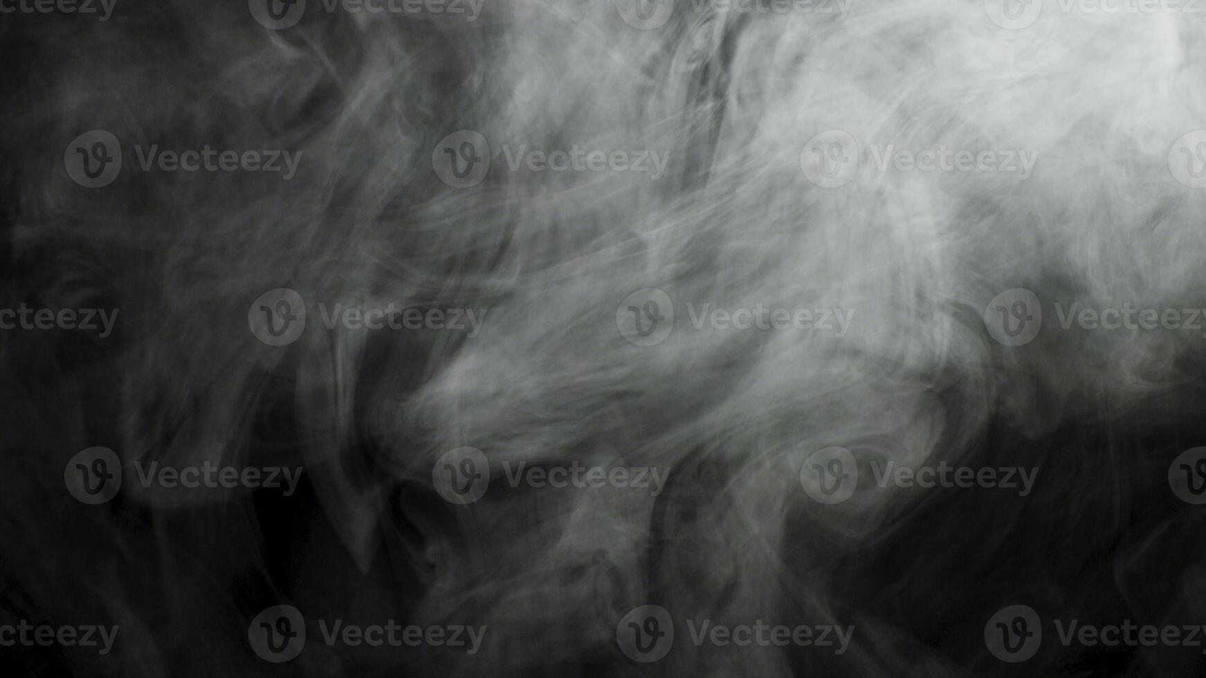 Close up for thick white smoke spreading over black background. Stock footage. Dense fog flying isolated in the dark. photo