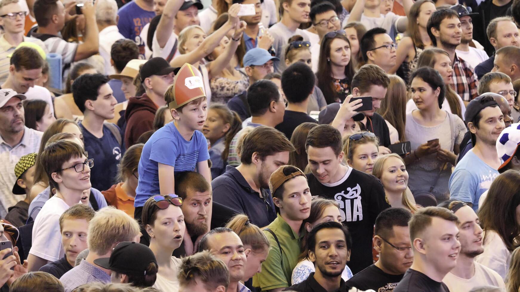 Yekaterinburg, Russia - June, 2018. FIFA World Cup 2018 many fans of different national football teams are standing and watching a football match in the fan zone photo