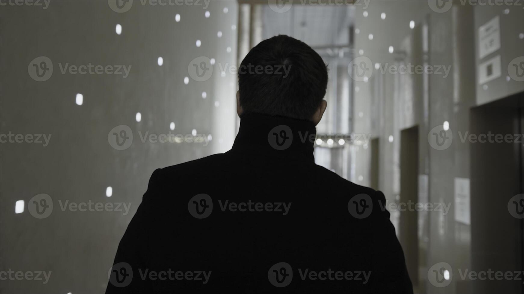 Back view of businessman walking in modern office building. Stock. The businessman stay in the business center photo