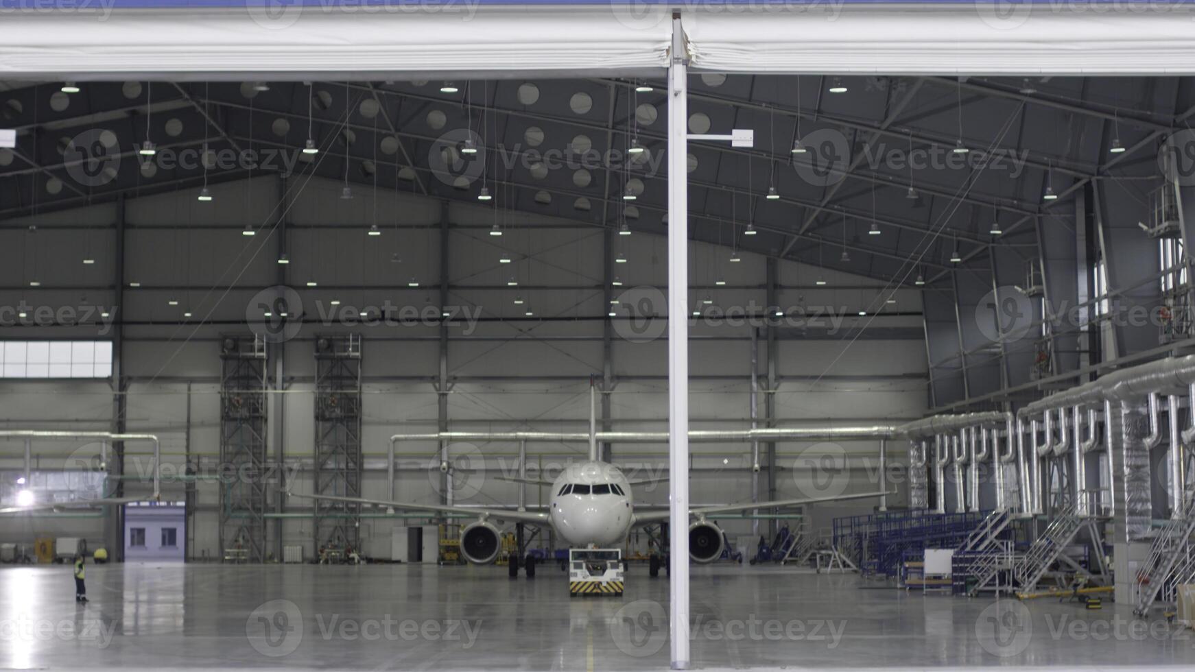 Roller shutter door and concrete floor of airport hangar and airplane background. Airport hangar from the outside with big tall doors. Front view. Aircraft Hangar photo