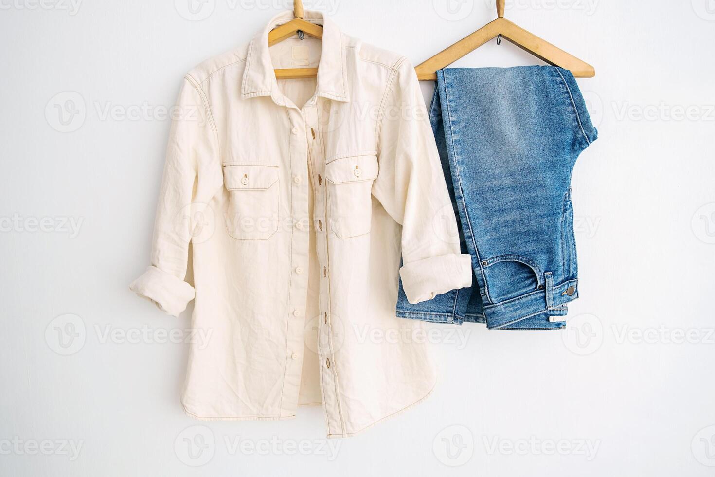 Casual clothing shirt and jeans on hangers, showcasing minimalist clothing concept. photo