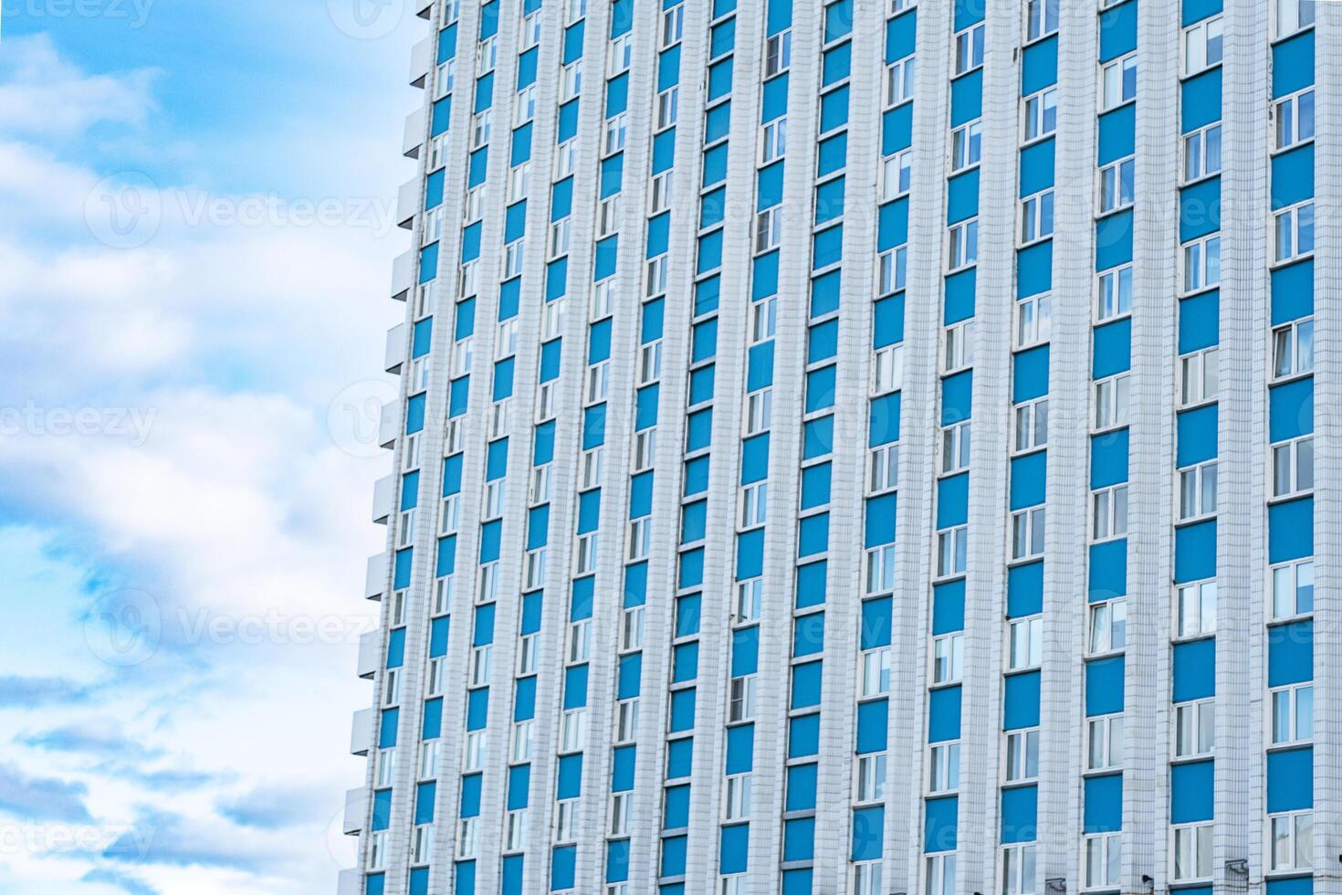 Modern building facade against cloudy sky. Urban architecture and design concepts. photo