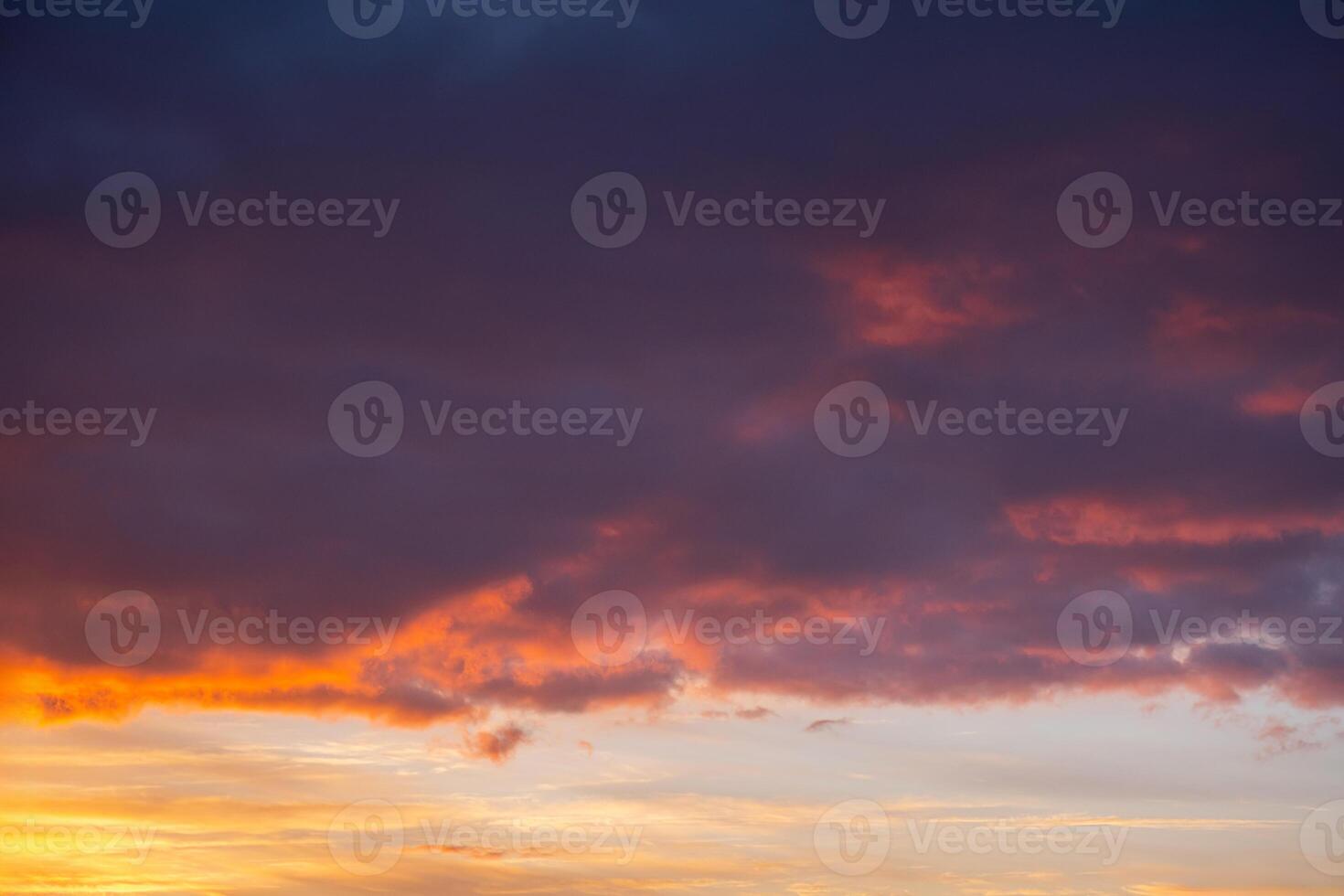 Vibrant sunset sky with dramatic clouds over calm horizon. photo