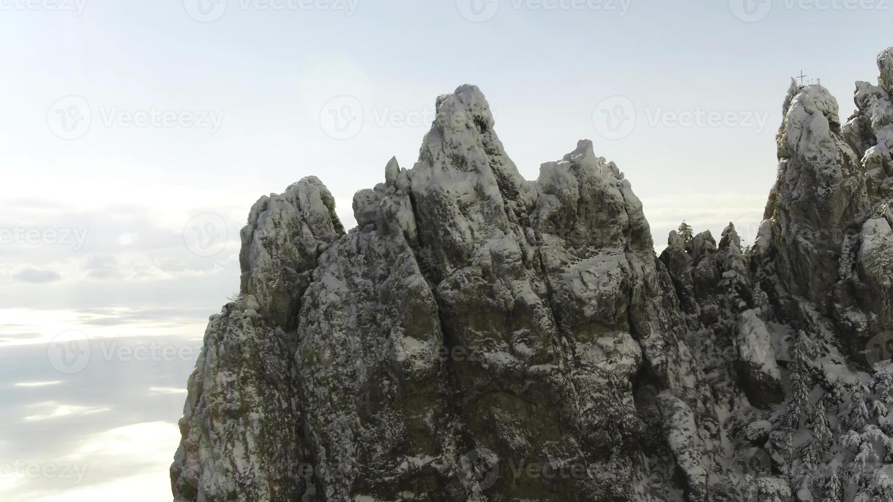 Close up for sharp rock formation on blue, cloudy sky background. Shot. Aerial for sharp peaks of mountain and a skyline on background. photo