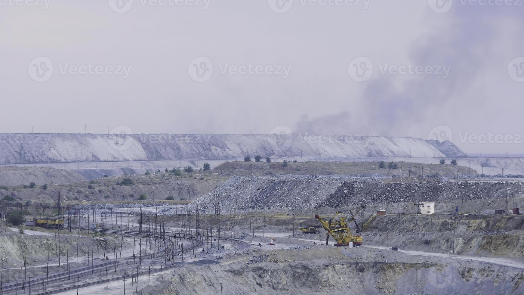 Panorama of an open quarry. Mining industry. Large quarry excavator in the background of hills of cruched stone next to a mining enterprise, panorama. Mining equipment photo