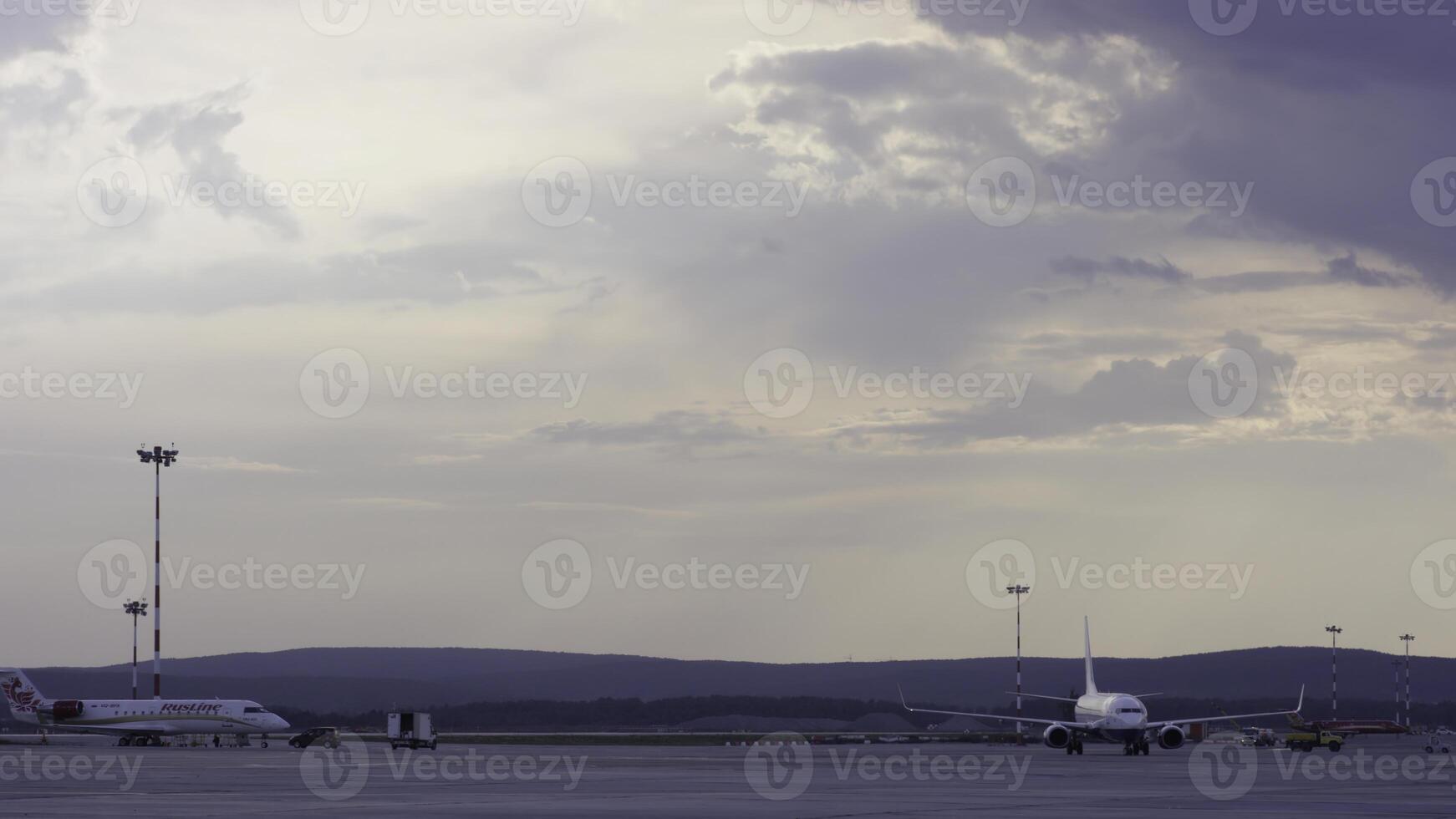 Airport workers handling airplane. Airplane parked at the airport and preparation for next flight. Closeup high detiled view on white modern passenger airplane standing on parking place photo