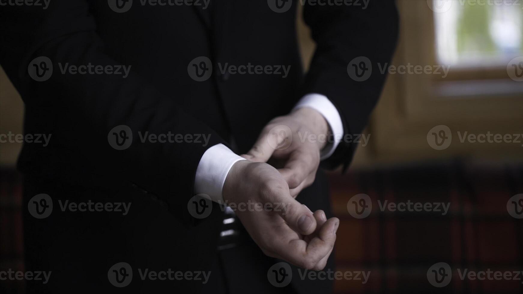 Man buttoning on a black jacket. Wedding details - elegant groom dressed wedding tuxedo costume is waiting for the bride. businessman buttoning jacket, getting dressed. Groom buttons jacket photo