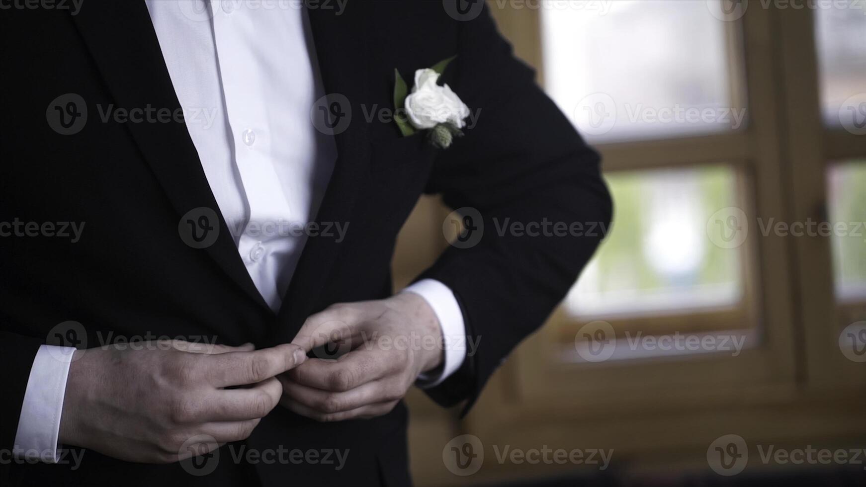 Man buttoning on a black jacket. Wedding details - elegant groom dressed wedding tuxedo costume is waiting for the bride. businessman buttoning jacket, getting dressed. Groom buttons jacket photo