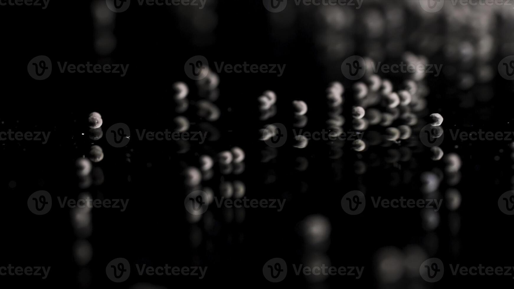 Close up of tiny gravel pile left on reflective black surface. Stock footage. Small stones at the laboratory during quality control of contruction materials process. photo