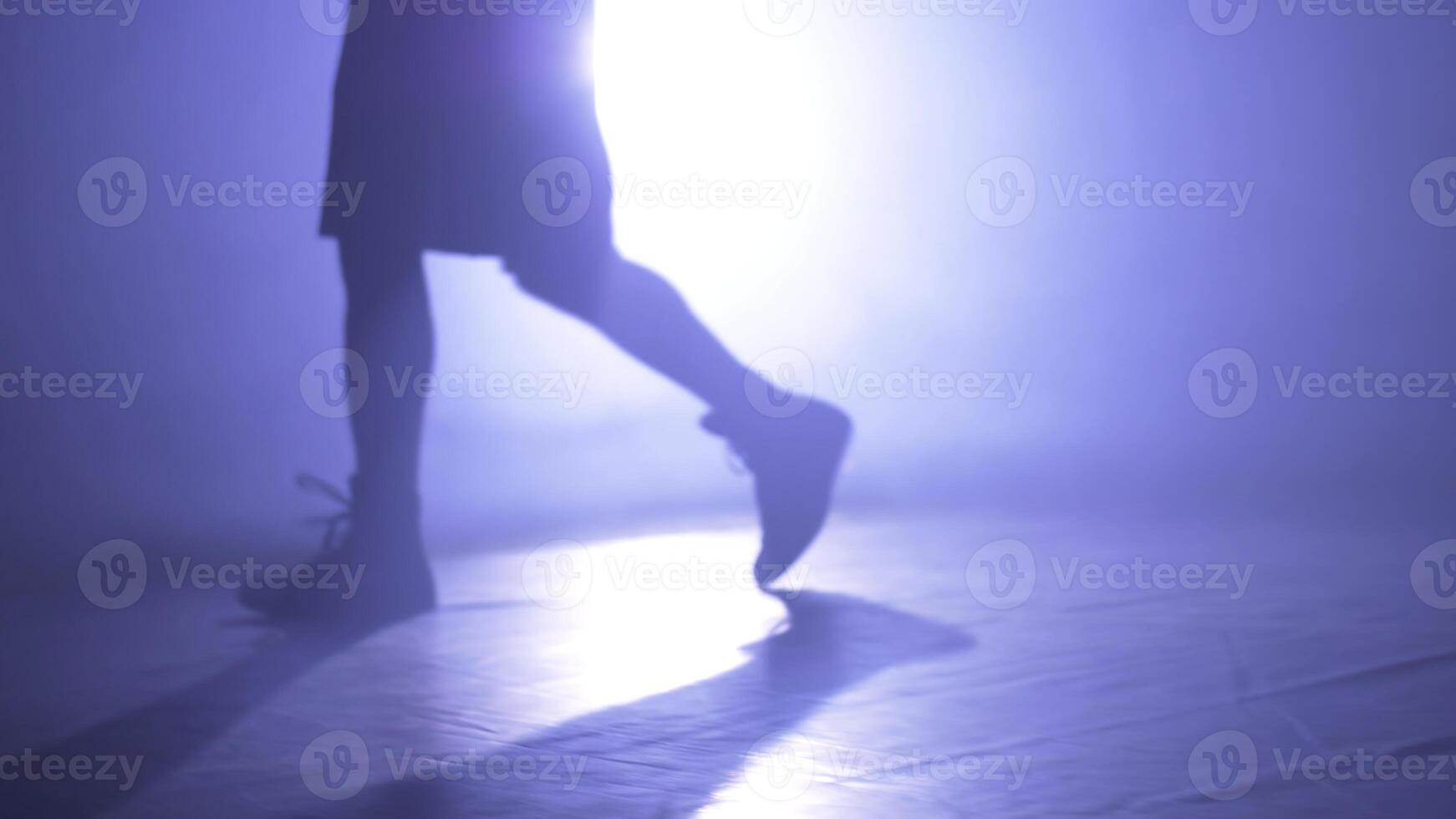 Bottom view of fighter training in the gym with smoke and light background. Silhouette of strong male boxer on dark background. Close up of athlete or sportsman moving fast while training photo