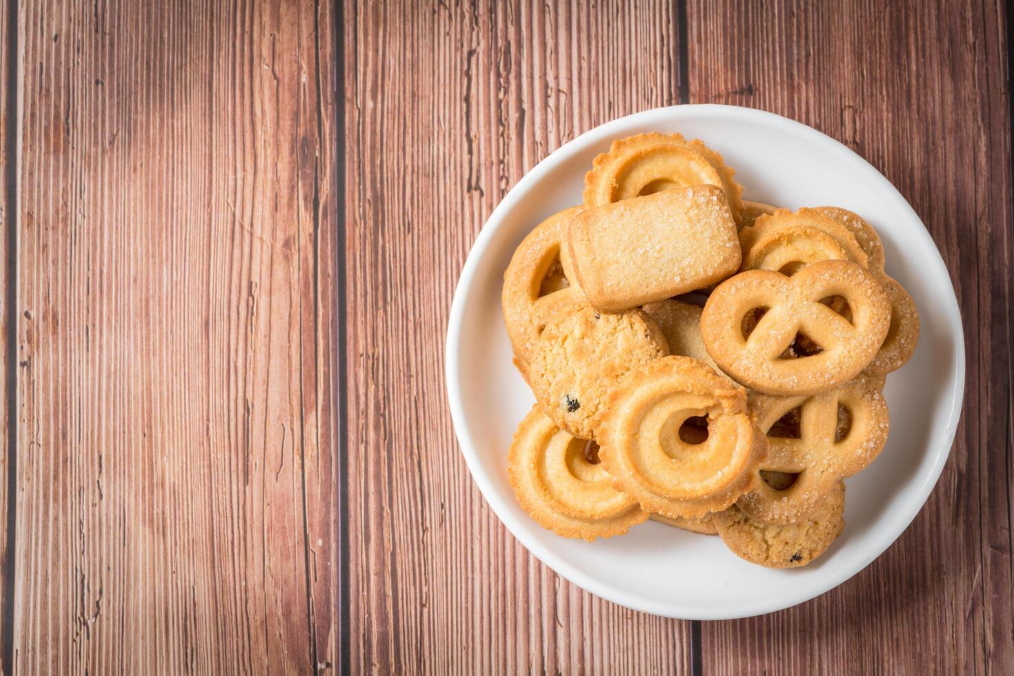 Five whole pretzel, round and rectangular shortbread biscuits with sugar on wood background. photo