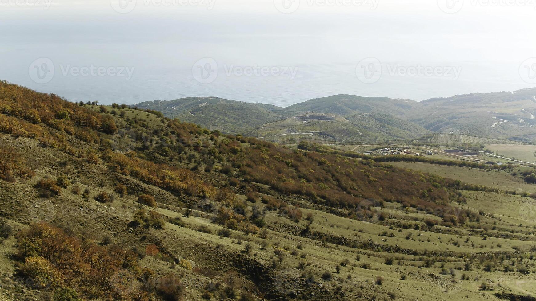 Aerial view of a green rural area under blue sky. Shot. Idyllic green valley natural scenery. Dramatic aerial view of idyllic rolling patchwork farmland with pretty wooded boundaries photo