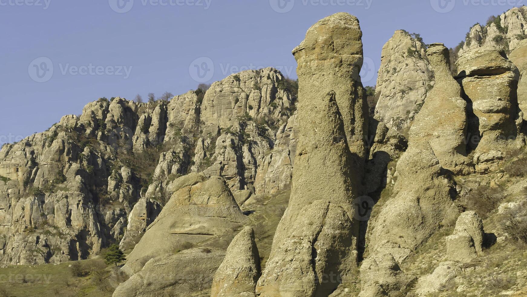 Picturesque landscape of mountains with green small trees on peaks in late autumn. Shot. Beautiful, unusual rocks and withered bushes in autumn sunset photo