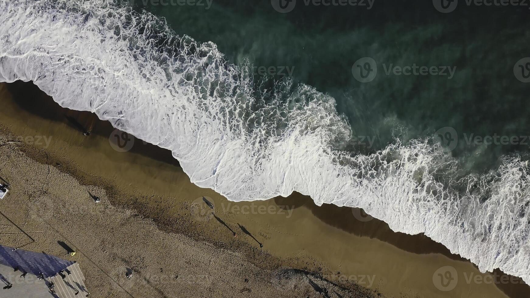 Sand beach. Stock. Top view of a beautiful sandy beach with the blue waves rolling into the shore. Sea background photo