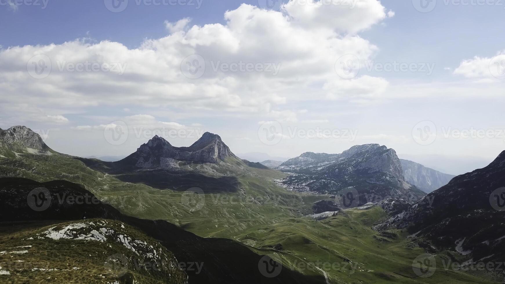 Top view of mountain panorama. Stock. Sunny day with clouds in mountains. Exciting landscape of mountains and cliffs. Mountain valley with rocky cliffs photo