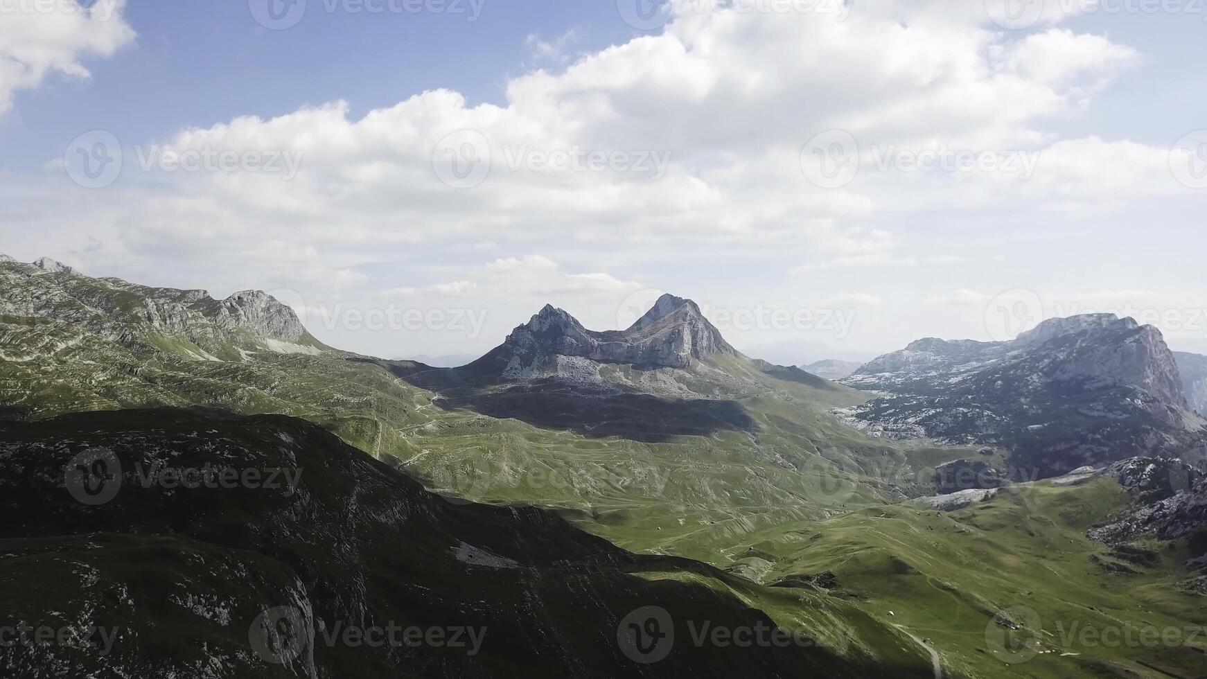 Top view of mountain panorama. Stock. Sunny day with clouds in mountains. Exciting landscape of mountains and cliffs. Mountain valley with rocky cliffs photo