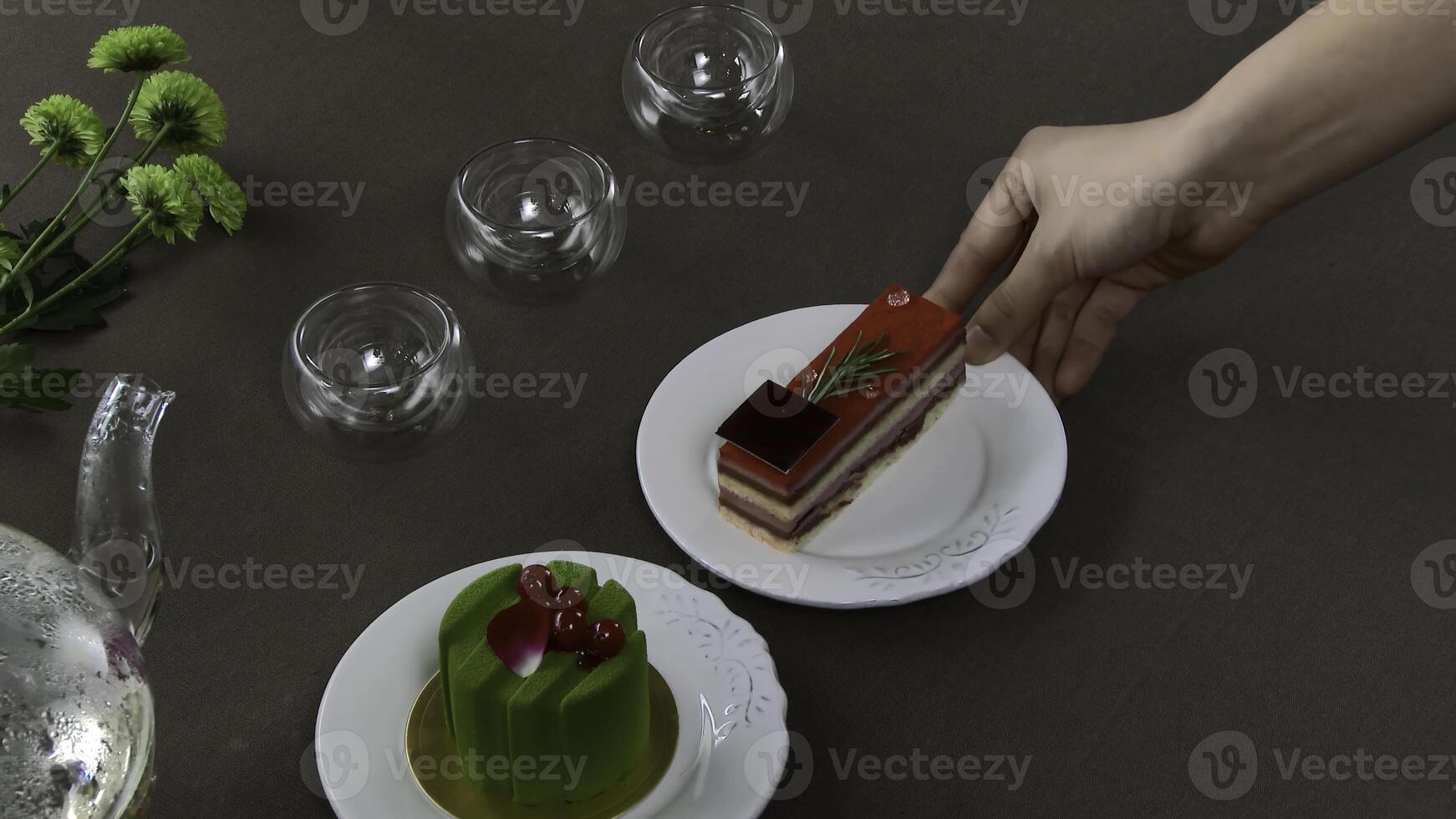 Beautiful transparent teapot kettle with tasty green black tea with apple, with candles and with dessert in the background. Turkish tea in traditional glass on wooden table. Cakes and glass teapot photo