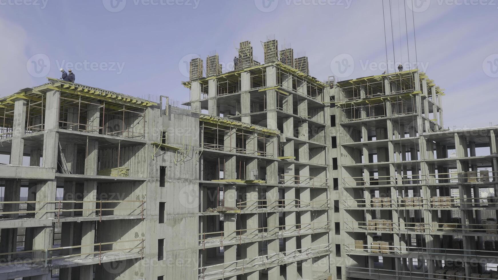 Building construction site work against blue sky. Workers at the construction site of an apartment building photo