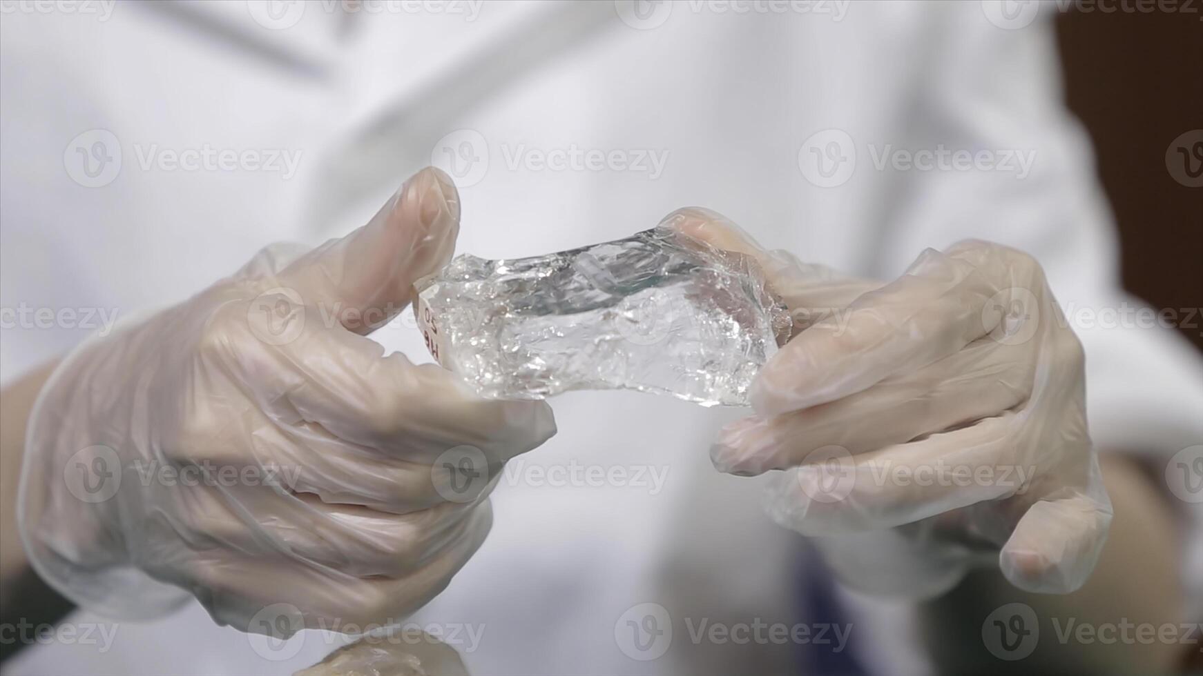 Natural stone amethyst or another mineral, stone. Wild amethyst in female hands in white gloves. Rock stone in hands photo