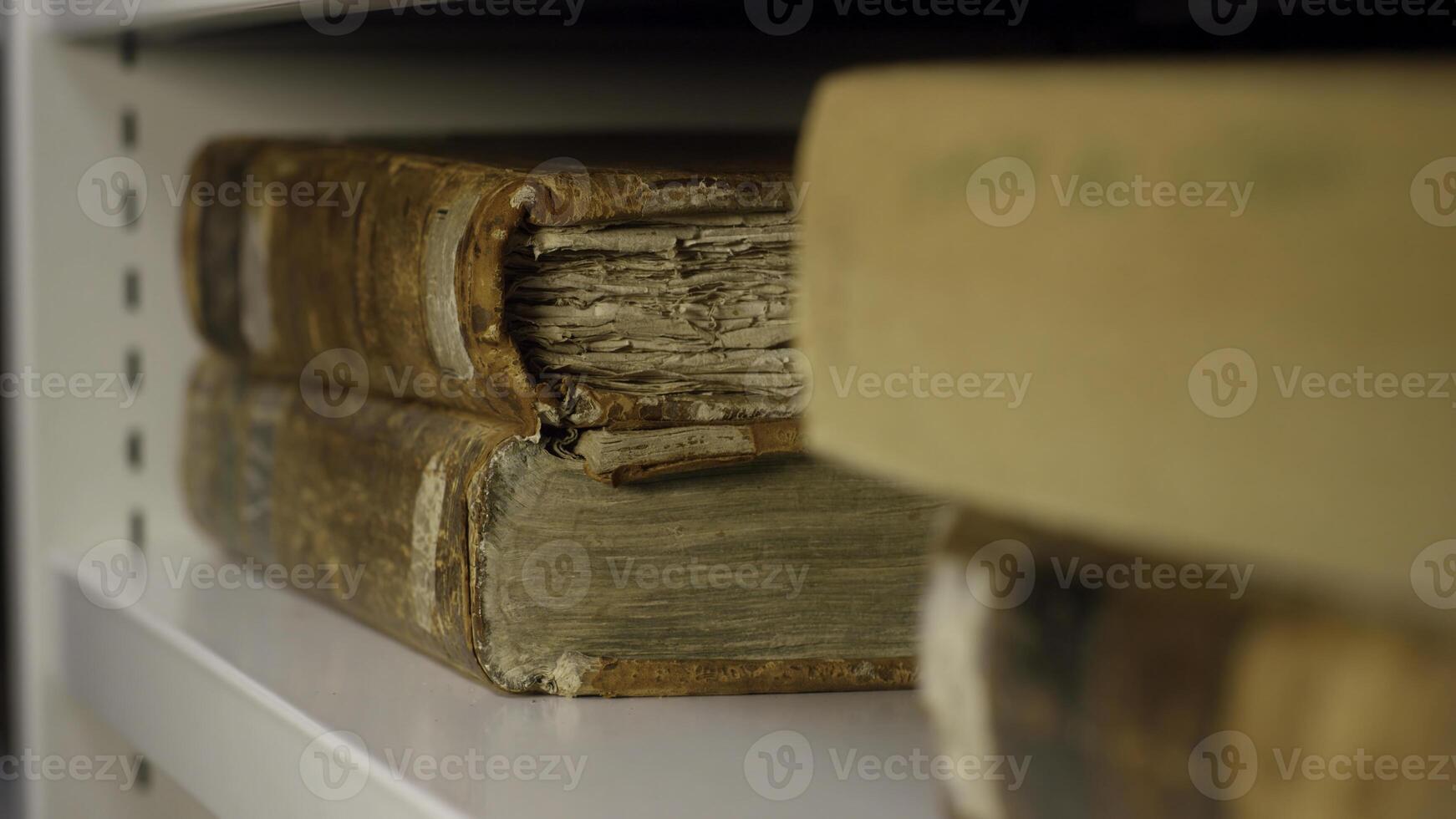 Expert takes an old book from the shelf. Stock footage. An ancient relic taken by gloved hands photo