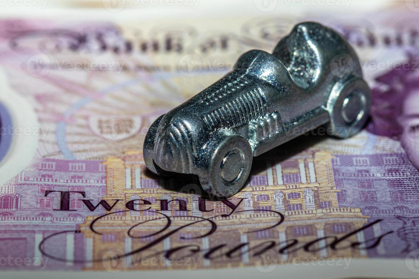 A silver toy car on top of a twenty pound note photo
