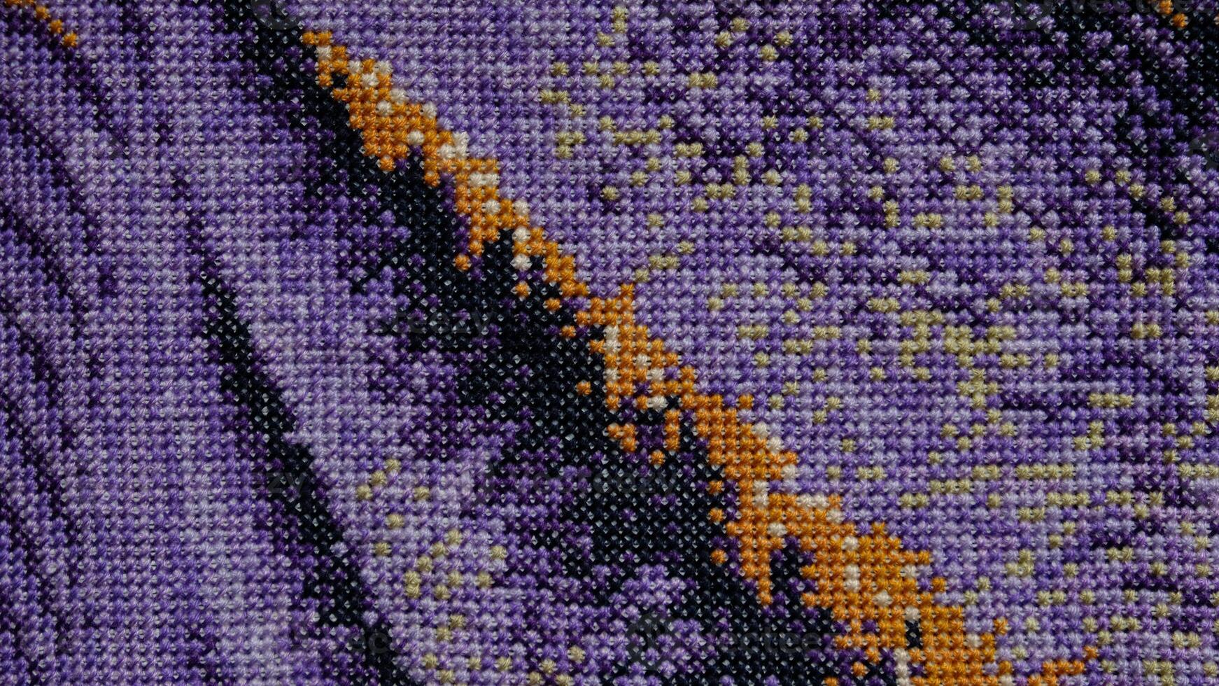 Purple, violet and brown close-up cross stitch background. Abstract Embroidered handmade Pattern. Needlework and DIY concept. Top view, macro, flat lay, mockup. photo