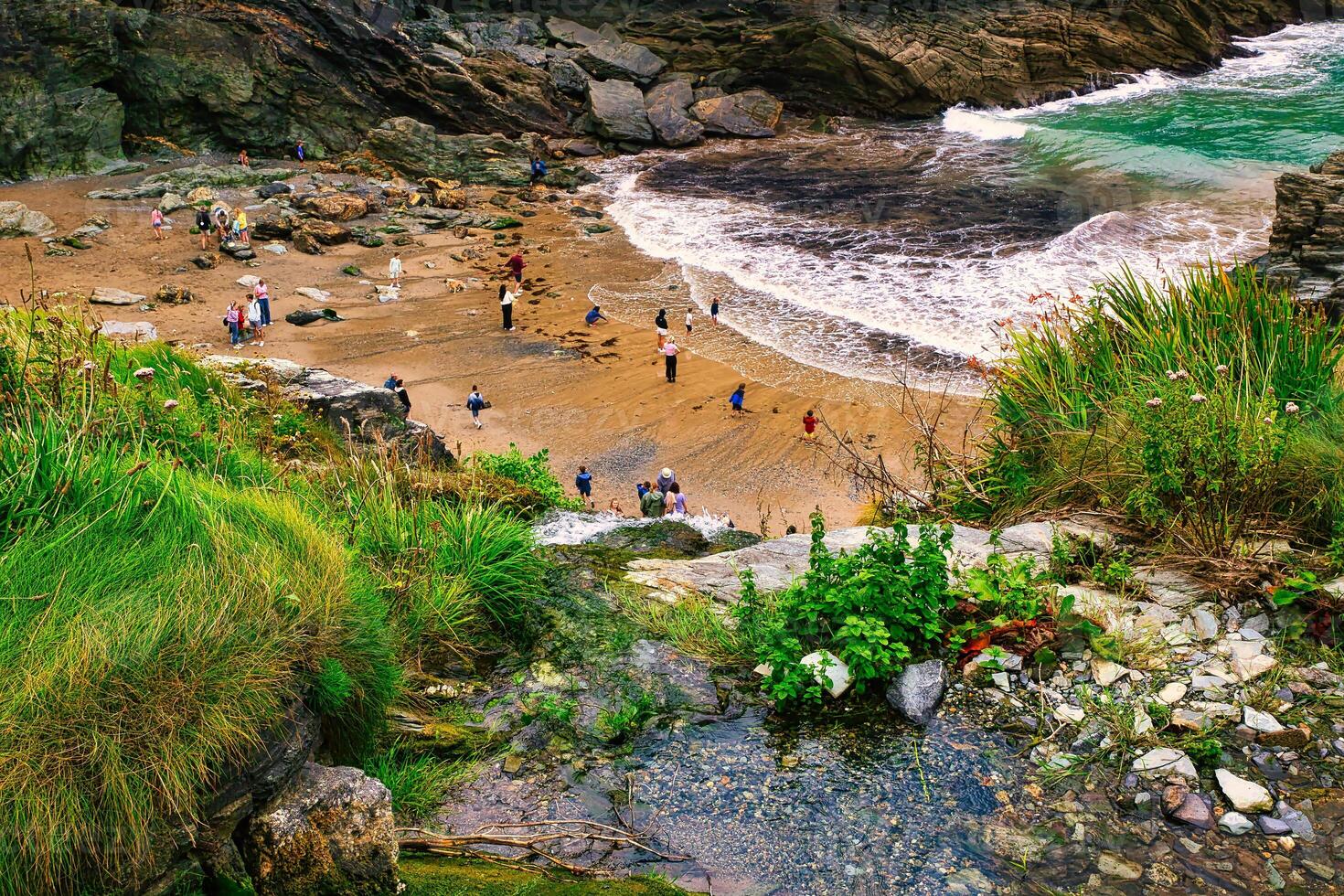 Scenic Beach View with People and Rocky Cliffs in Tintagel, Cornwall, UK photo