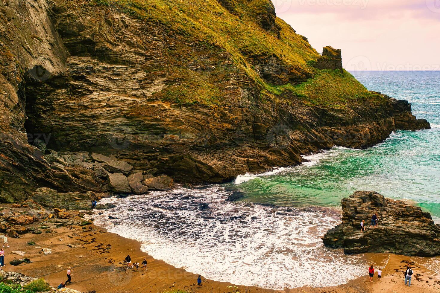 Scenic Beach with Rocky Cliffs and Gentle Waves in Tintagel, Cornwall, UK photo