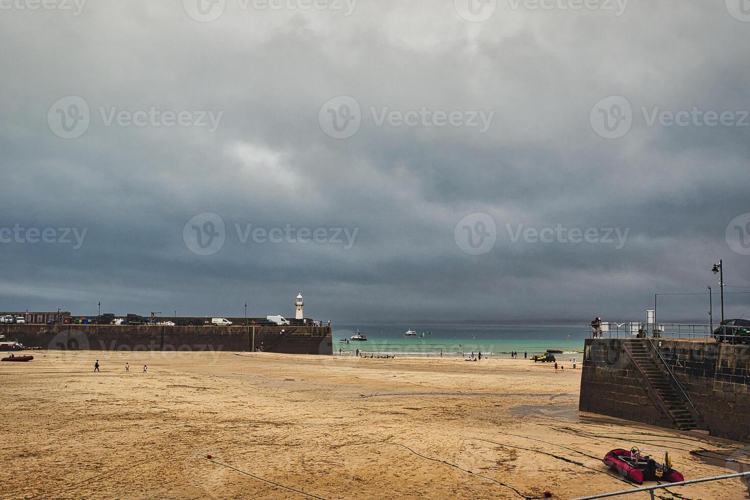 Coastal Scene with Lighthouse and Cloudy Sky in St Ives, Cornwall, UK photo