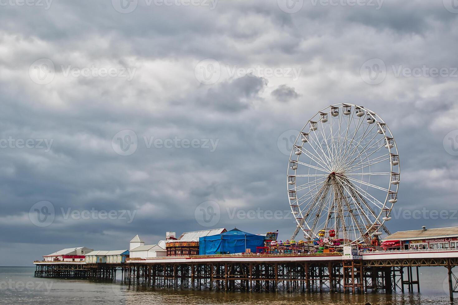 Scenic Pier with Ferris Wheel Under Cloudy Skies in Blackpool, UK photo