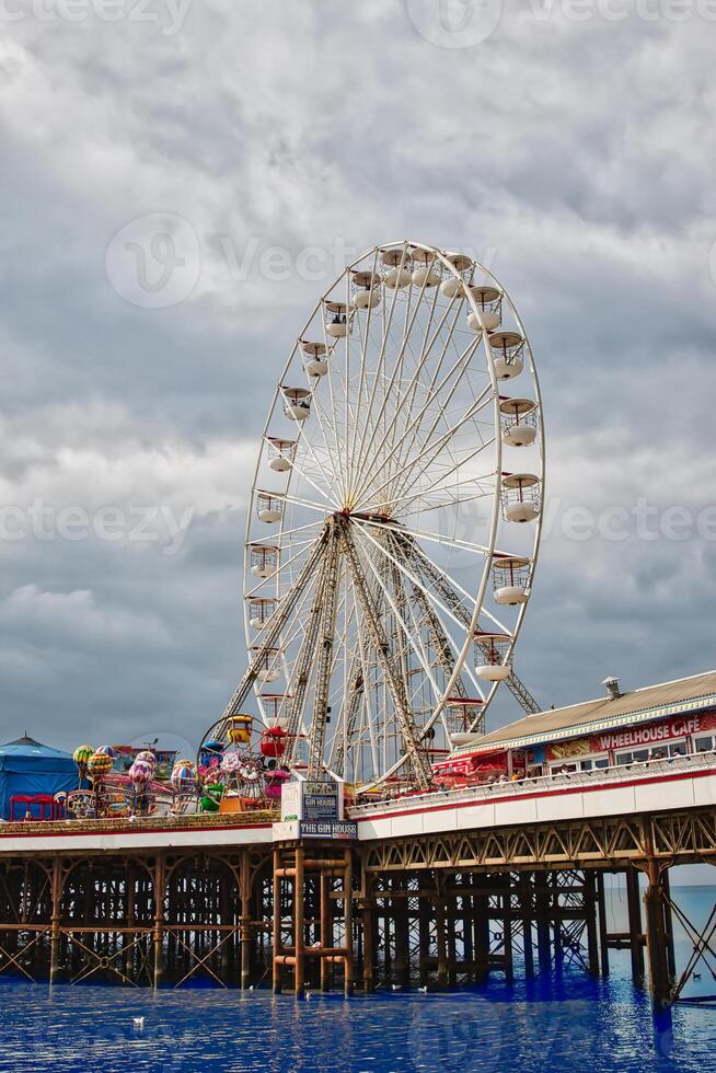 Ferris Wheel on a Pier with Amusement Rides in Blackpool, UK photo