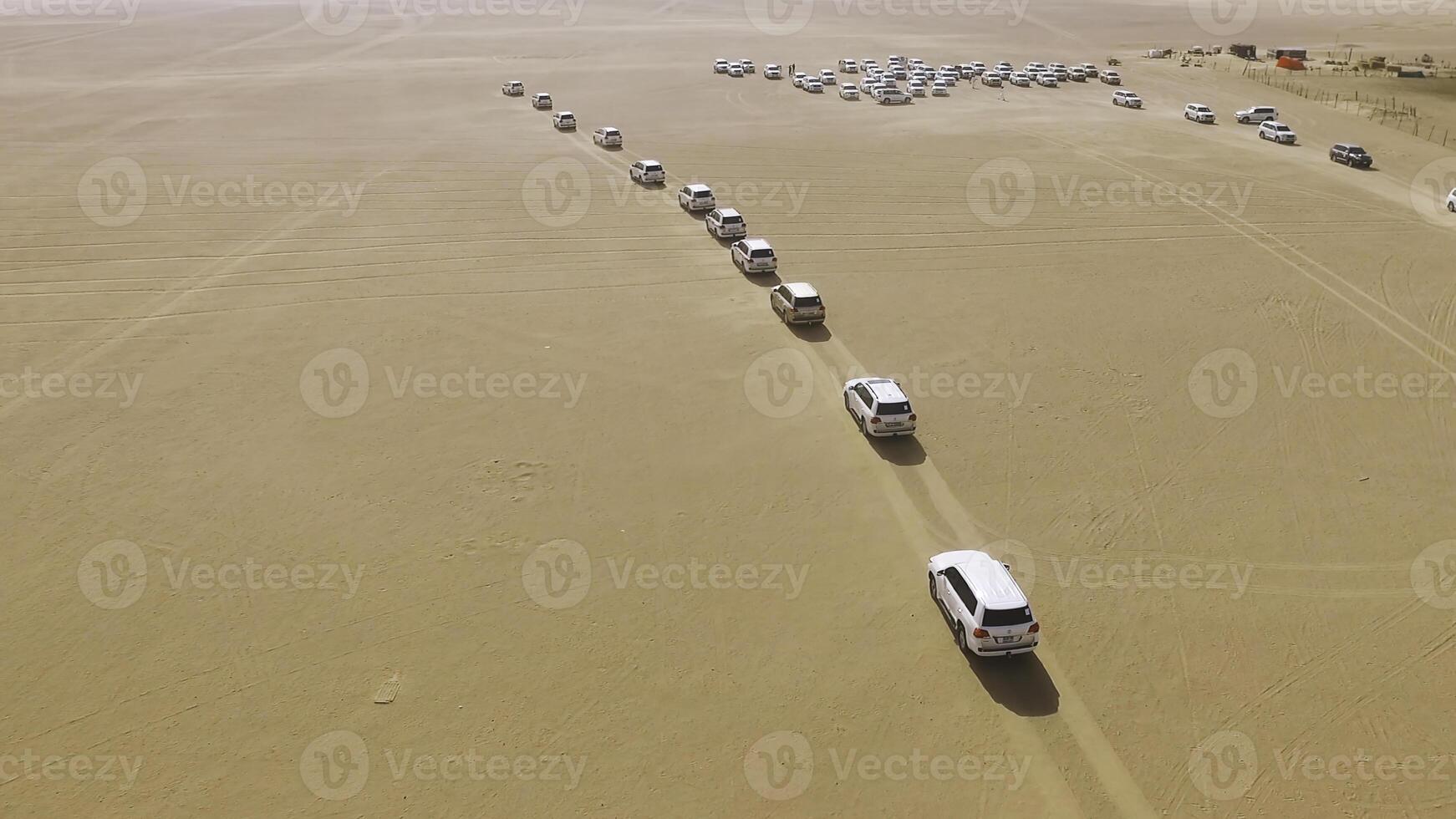4x4 SUVs cars driving through the sand dunes in the desert of Abu Dhabi. Stock. Top view on SUVs in the desert photo